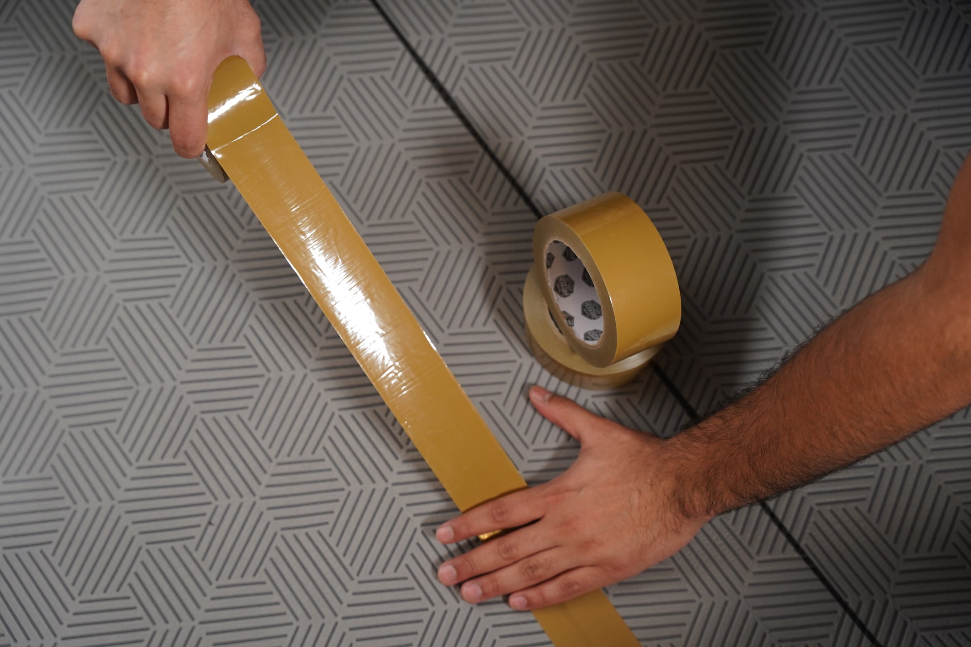 Close-up of Gator Guard® Hexa Grip Tape roll showing reinforced adhesive design for securing temporary floor protection.