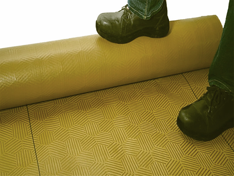 Gator Guard Gold floor protection roll partially unrolled with worker’s boot on it